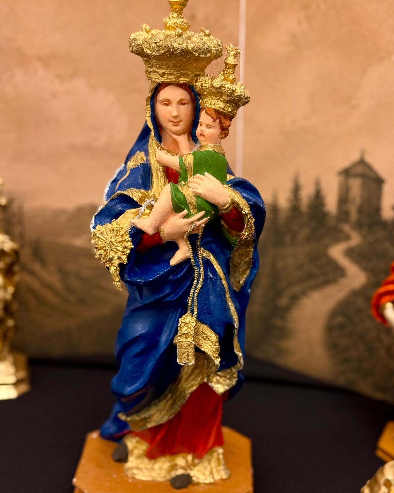 Madonna del Carmine col Bambino, veste policroma dipinta e dorata a mano, sul fondale del santuario